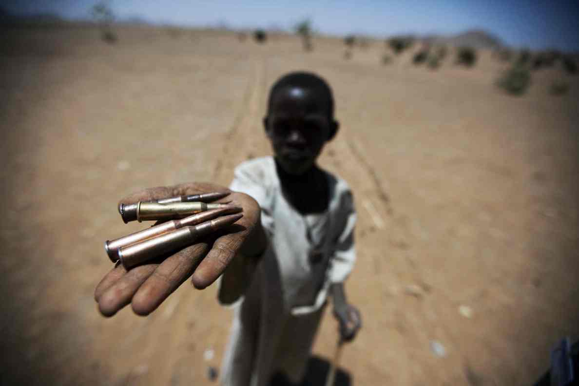 27 March 2011. Rounyn: A child collects bullets from the ground in Rounyn, a village located about 15 km north of Shangil Tobaya, North Darfur. Most of the population in Rounyn recently fled to camps for displaced people due to the clashes between the Government and the armed movements.  Photo by Albert Gonzalez Farran / UNAMID