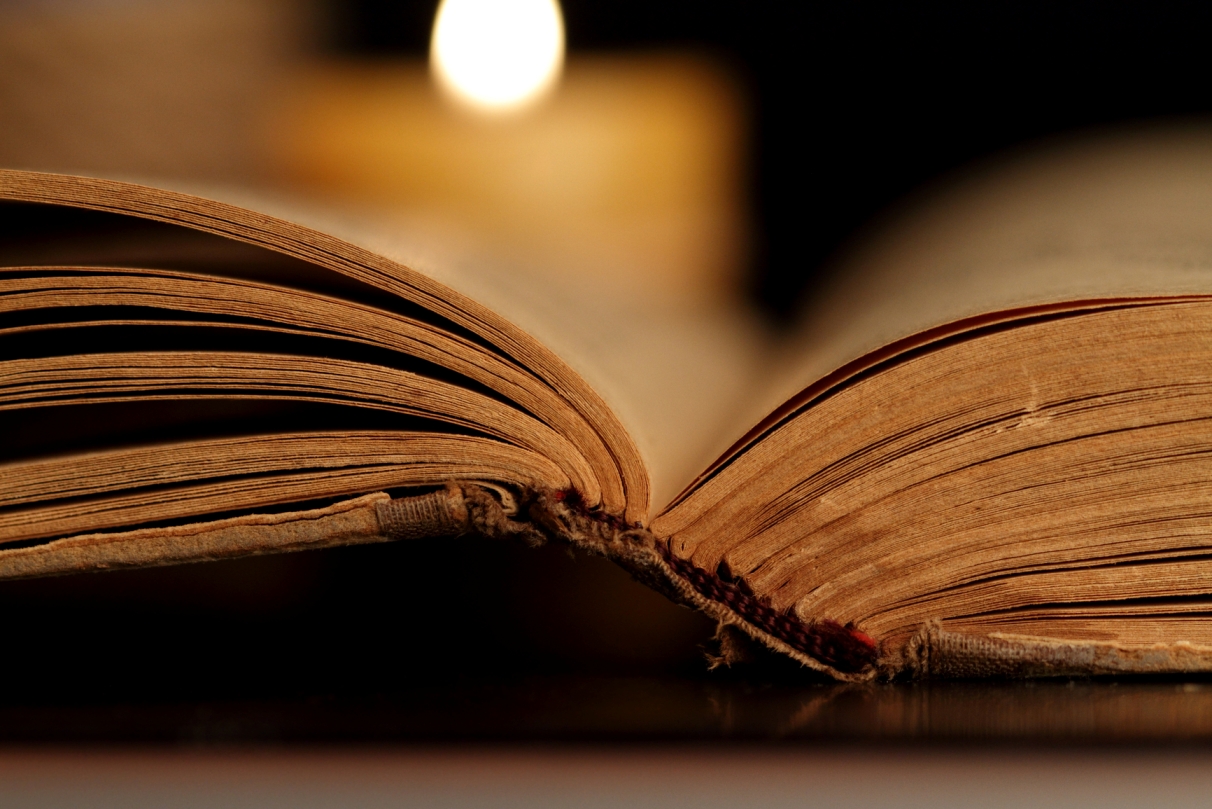 Candle and Opened Old Bible